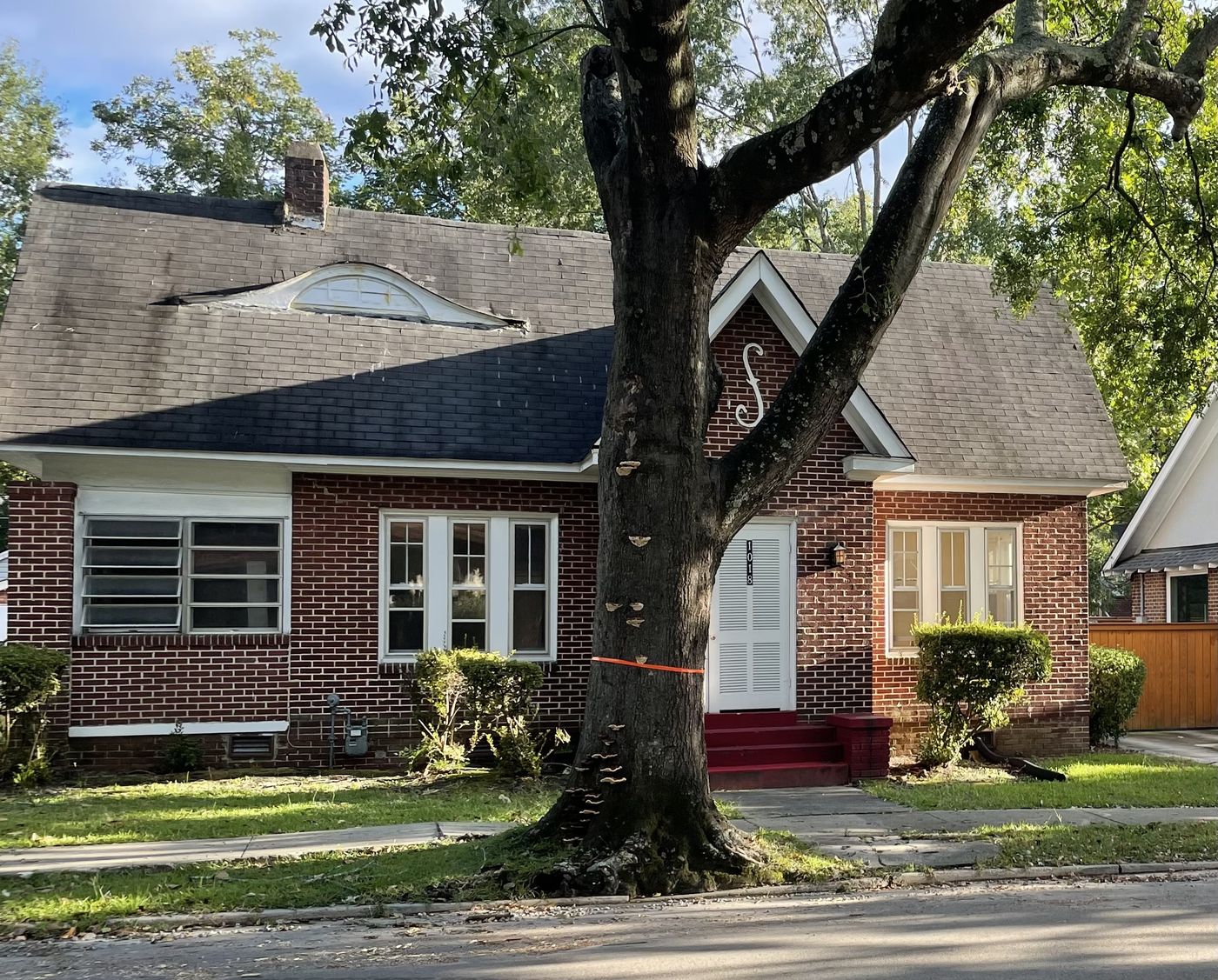 Brick cottage before work, with failing roof and damaged eyebrow dormer