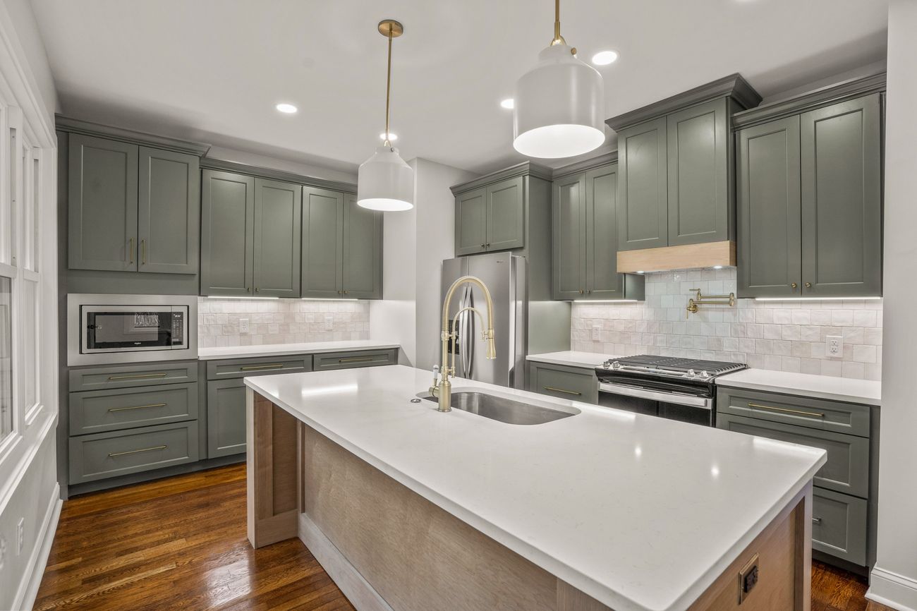Finished sage green kitchen looking toward the range wall