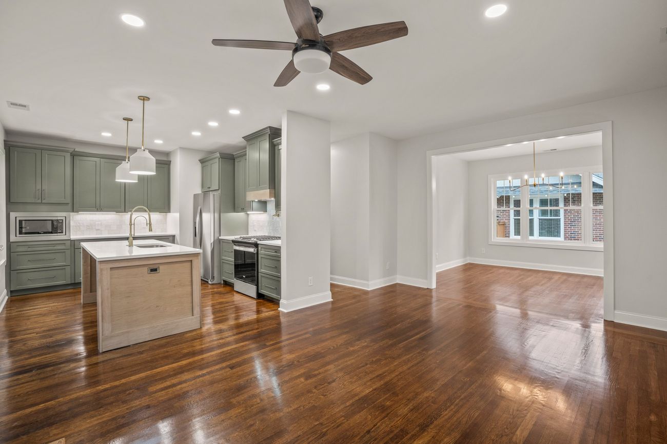 The same space finished, looking across the living room to the kitchen and dining room