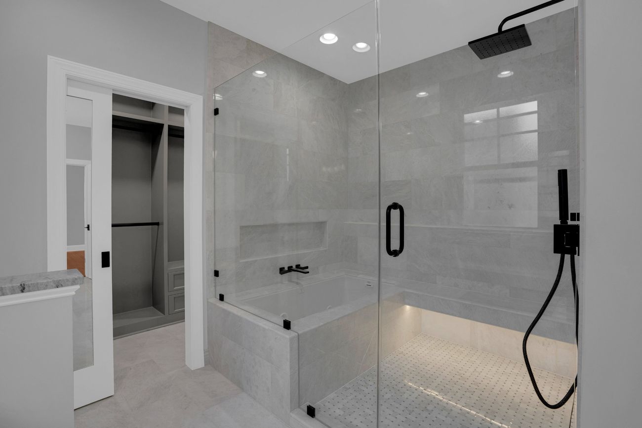 Finished bath in grey marble, looking toward the tub and shower