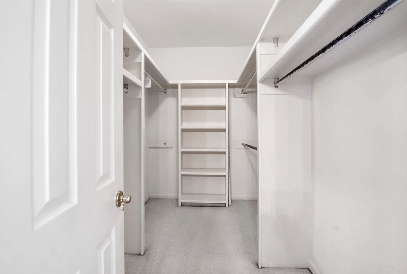 Original closet with white melamine shelving and carpet